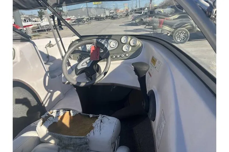 Slide: The Image of 2006 Tahoe 206 boat interior with worn seat and steering wheel. - 12