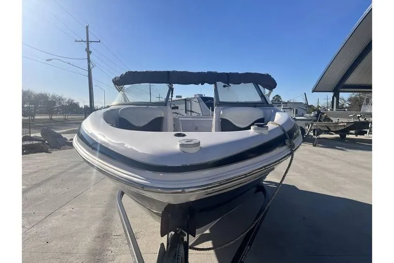 Slide: The Image of 2006 Tahoe 206 boat on trailer under clear blue sky. - 2