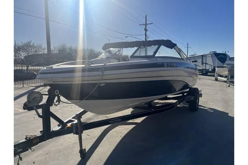 Slide: The Image of 2006 Tahoe 206 boat on trailer under clear blue sky. - 3