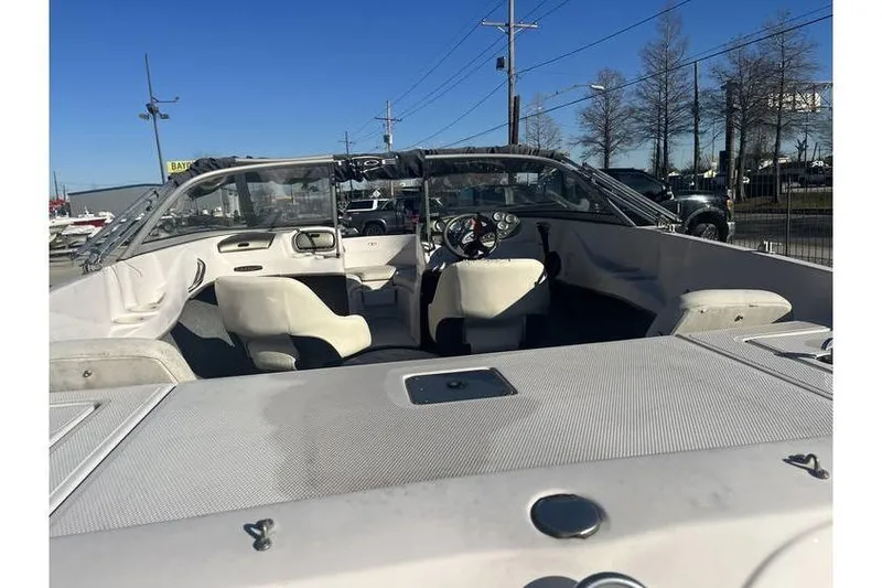 Slide: The Image of 2006 Tahoe 206 boat interior with steering wheel and seating under clear blue sky. - 9