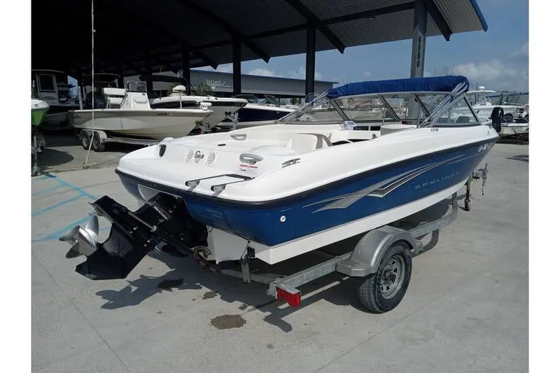 Slide: The Image of 2008 Bayliner 175 boat on trailer, blue and white, parked in marina. - 4