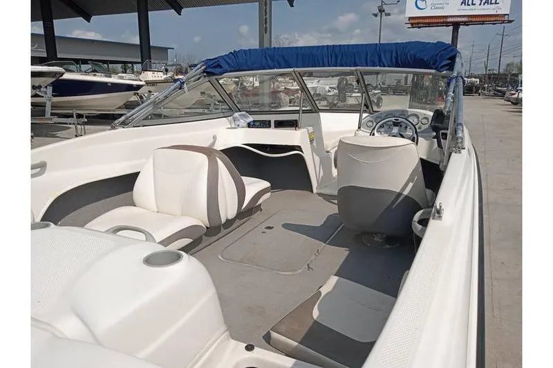 Slide: The Image of 2008 Bayliner 175 boat interior with seating and steering wheel, parked outdoors. - 6