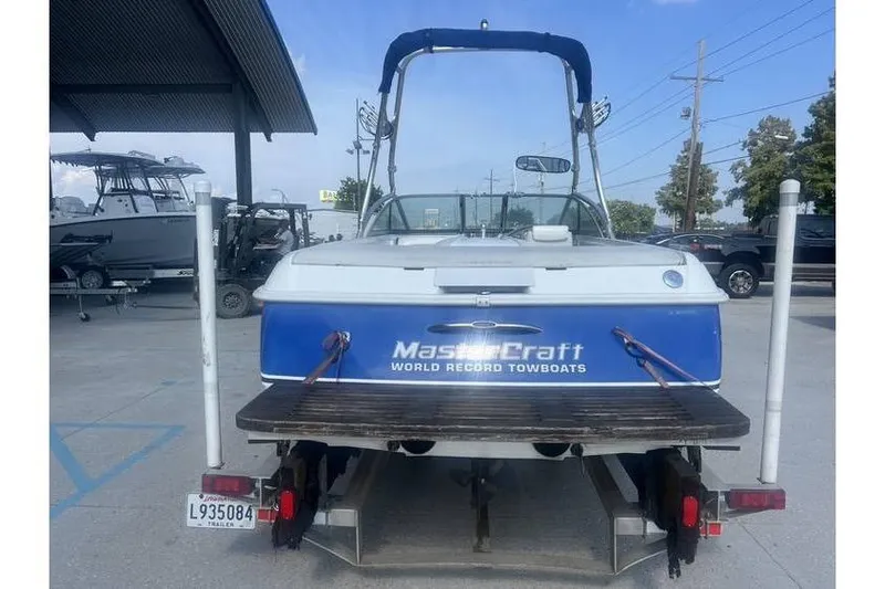 Slide: The Image of 1999 MasterCraft Prostar 205 boat on trailer, rear view, in a parking area. - 3