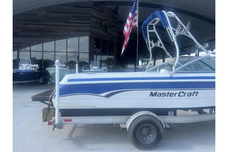 Slide: The Image of 1999 MasterCraft Prostar 205 boat on trailer, American flag, dealership background. - 4