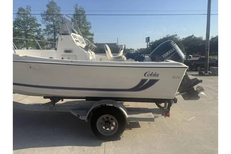 Slide: The Image of 1999 Cobia 194 Center Console boat on trailer with Yamaha outboard motor. - 3