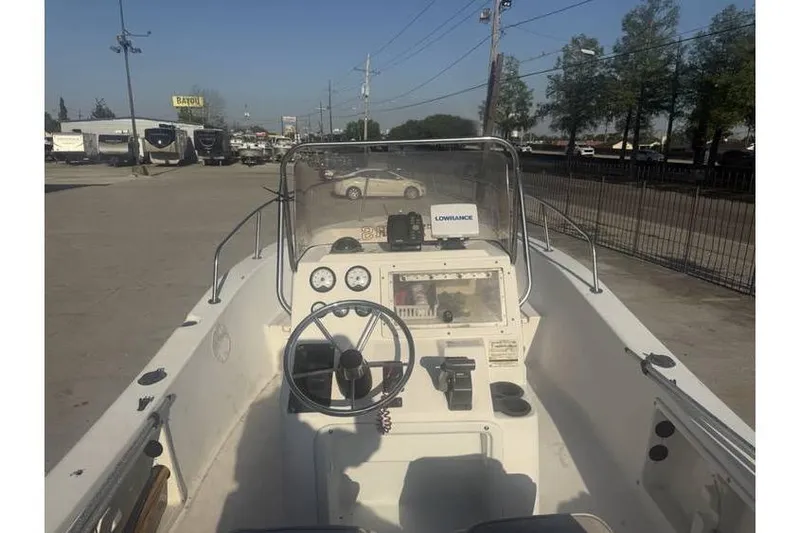 Slide: The Image of 1999 Cobia 194 Center Console boat with steering wheel and dashboard, parked outdoors. - 6