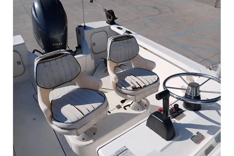 Slide: The Image of Two white boat seats and steering wheel on a 2000 Trophy 1800 model. - 12