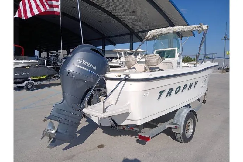 Slide: The Image of 2000 Trophy 1800 boat with Yamaha outboard motor on trailer, parked outdoors. - 3
