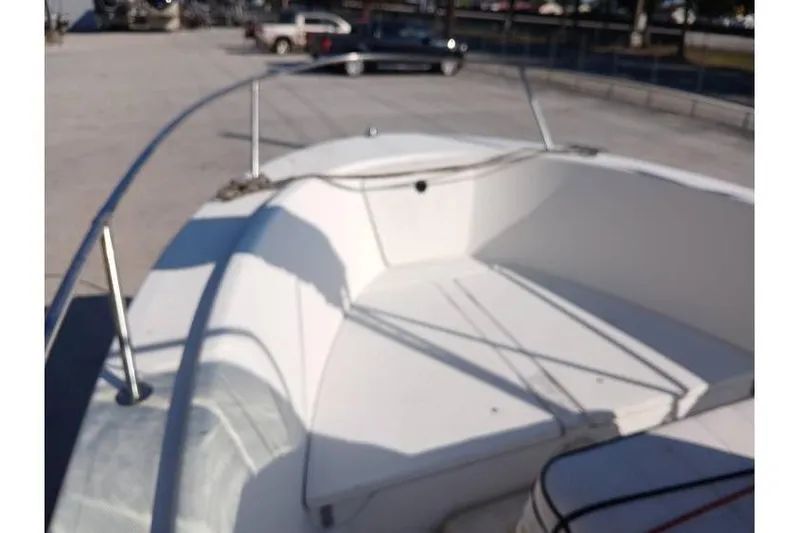 Slide: The Image of 2000 Trophy 1800 boat interior with seating and railing in a parking area. - 6