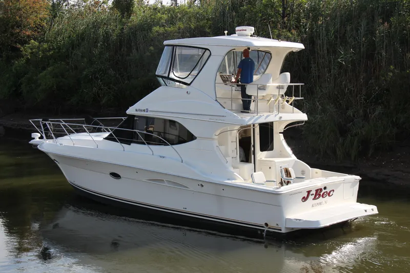Slide: The Image of 2003 Silverton 38 Convertible yacht cruising on a calm river. - 10