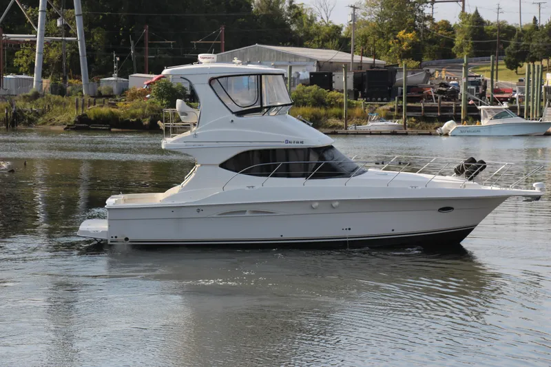 Slide: The Image of 2003 Silverton 38 Convertible yacht cruising on a calm river. - 22