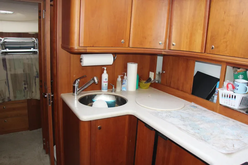 Slide: The Image of 2003 Silverton 38 Convertible yacht kitchen with wooden cabinets and sink. - 42