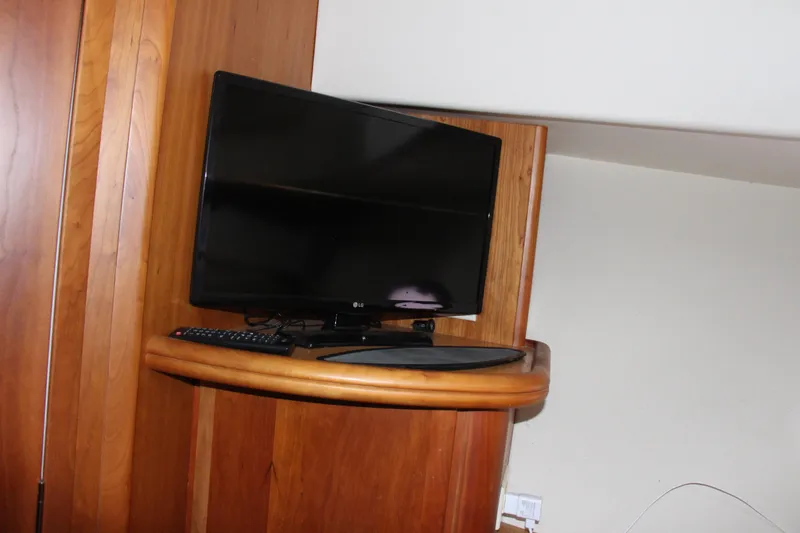 Slide: The Image of Flat-screen TV on wooden shelf inside 2003 Silverton 38 Convertible yacht. - 46