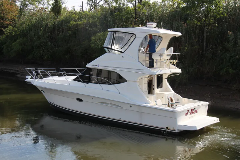 Slide: The Image of 2003 Silverton 38 Convertible yacht cruising on a calm river. - 8