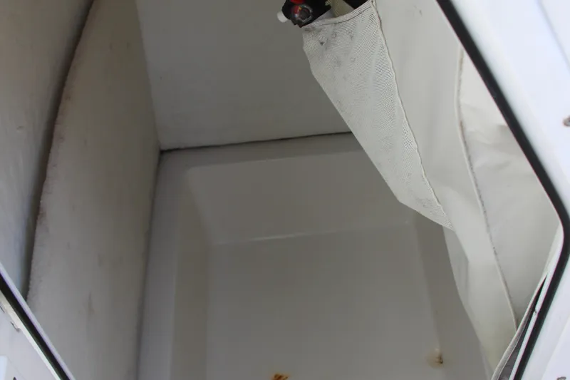 Slide: The Image of Storage compartment of 2019 Sea Hunt Triton 210 boat, featuring a white interior. - 15