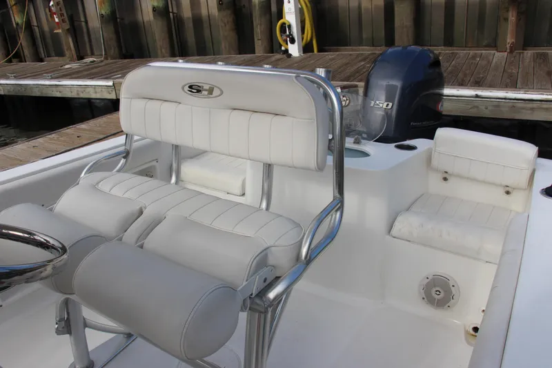 Slide: The Image of 2019 Sea Hunt Triton 210 boat interior with white seating and Yamaha 150 engine. - 17