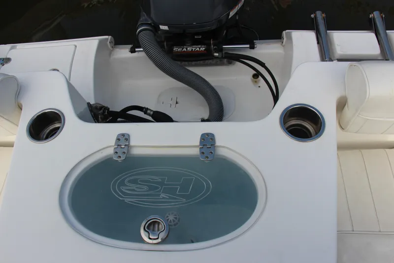 Slide: The Image of 2019 Sea Hunt Triton 210 boat interior with cup holders and storage compartment. - 19