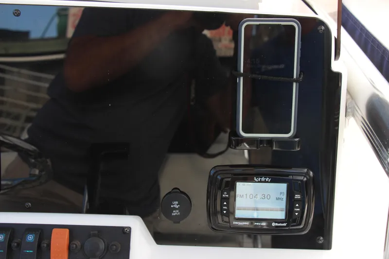Slide: The Image of Dashboard of 2019 Sea Hunt Triton 210 with radio and phone holder. - 25
