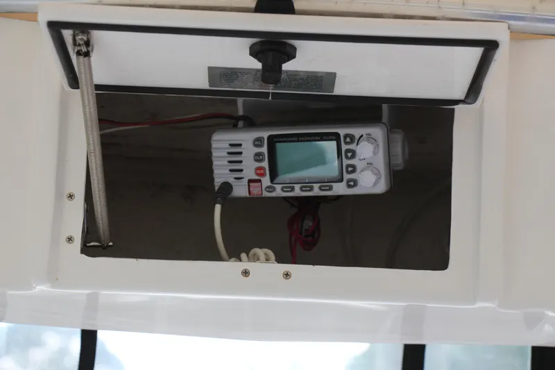 Slide: The Image of 2019 Sea Hunt Triton 210 boat radio compartment with marine communication device. - 27