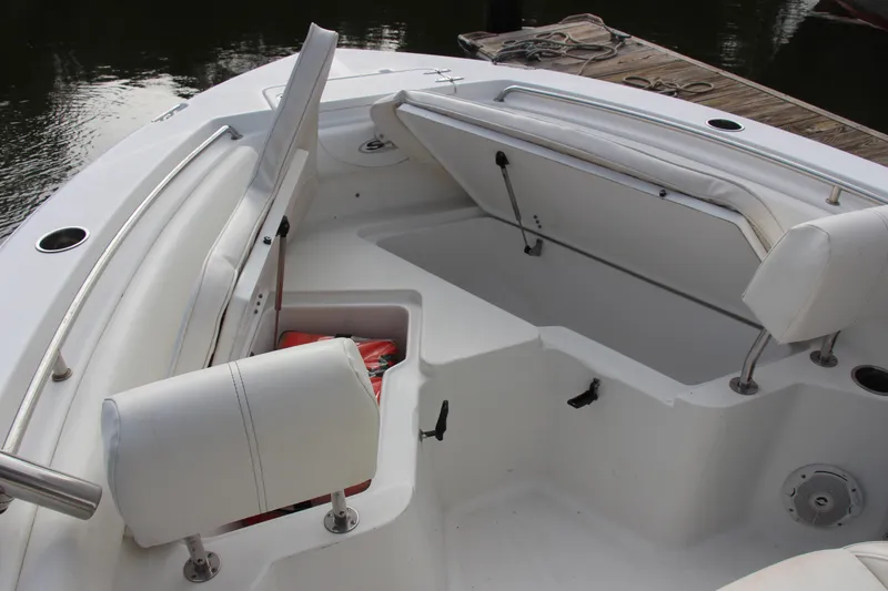 Slide: The Image of 2019 Sea Hunt Triton 210 boat interior with open storage compartments and cushioned seating. - 29