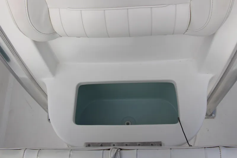 Slide: The Image of 2019 Sea Hunt Triton 210 boat interior with white cushioned seating and storage compartment. - 35