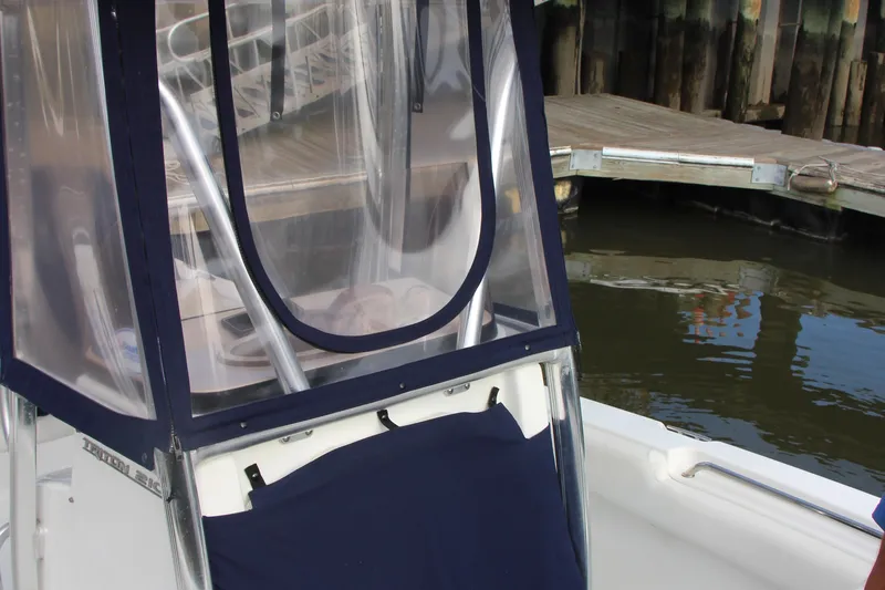 Slide: The Image of 2019 Sea Hunt Triton 210 boat with protective cover at dockside. - 36