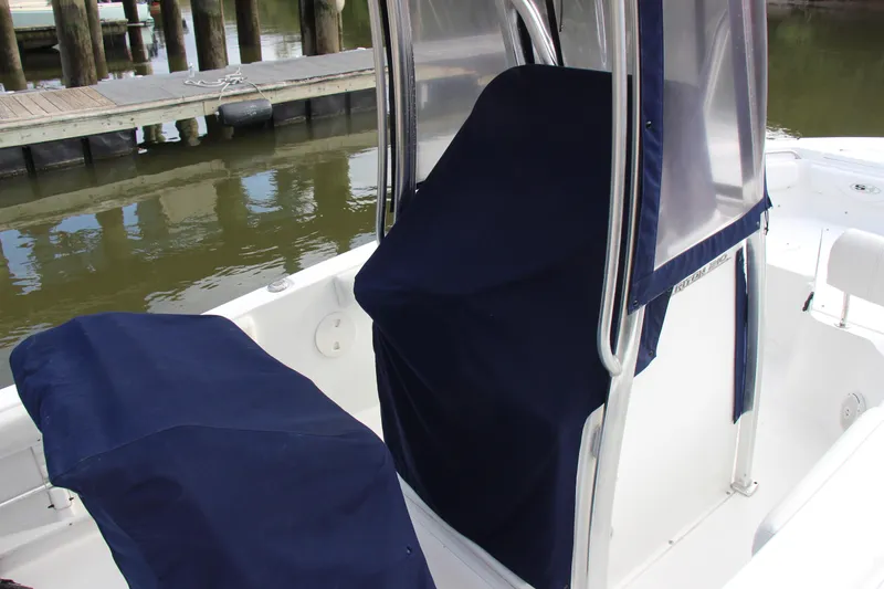 Slide: The Image of 2019 Sea Hunt Triton 210 boat interior with protective covers at a dock. - 38