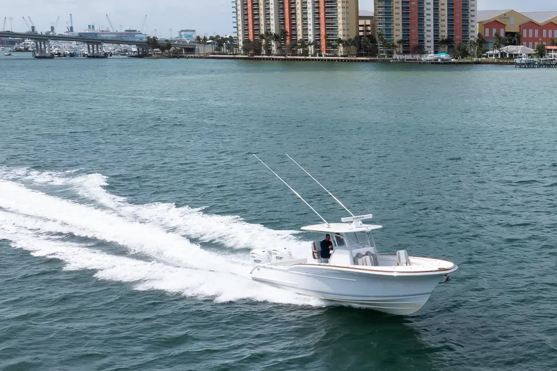 Slide: The Image of 2026 Buddy Davis 34 Center Console cruising on water near city skyline. - 23