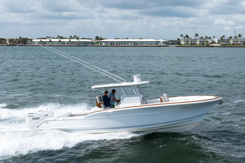 Slide: The Image of 2026 Buddy Davis 34 Center Console boat cruising on water with coastal buildings in background. - 35