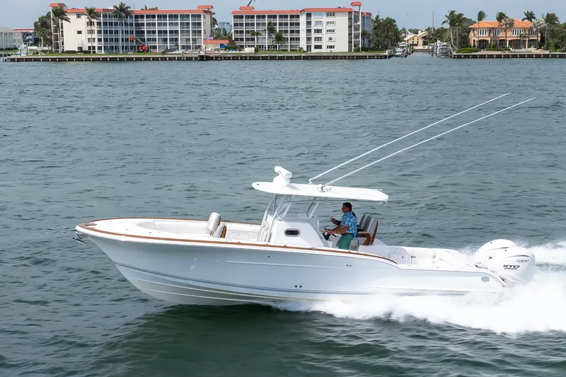 Slide: The Image of 2026 Buddy Davis 34 Center Console cruising on water near coastal buildings. - 44