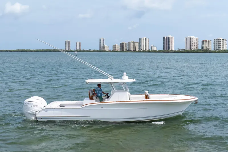 Slide: The Image of 2026 Buddy Davis 34 Center Console boat cruising on water with city skyline backdrop. - 50