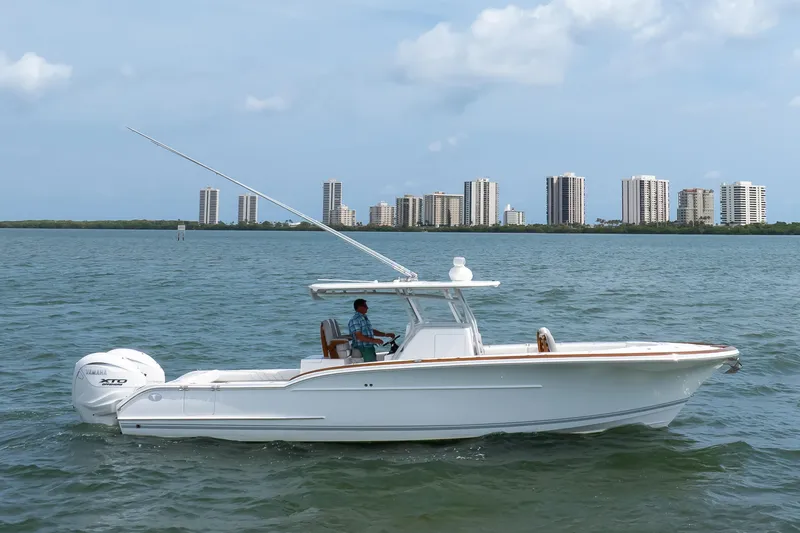 Slide: The Image of 2026 Buddy Davis 34 Center Console boat on water with city skyline background. - 51