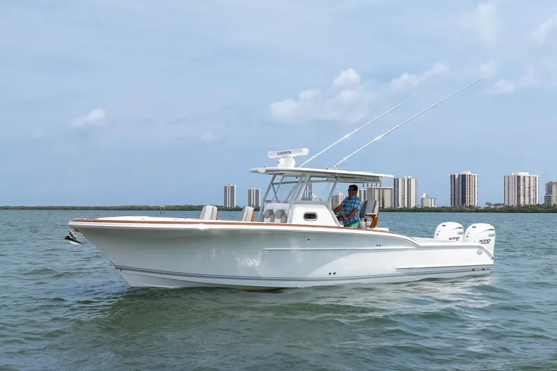 Slide: The Image of 2026 Buddy Davis 34 Center Console boat cruising on water near city skyline. - 8