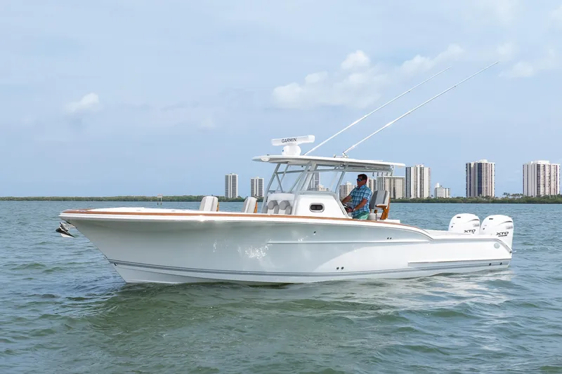 Slide: The Image of 2026 Buddy Davis 34 Center Console boat cruising on water near city skyline. - 9