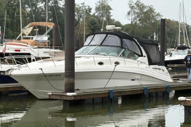 The Image of 2004 Sea Ray 340 Sundancer docked at a marina, surrounded by other boats. - 0