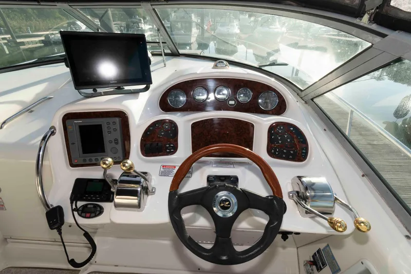 Slide: The Image of 2004 Sea Ray 340 Sundancer helm with steering wheel, gauges, and navigation equipment. - 10