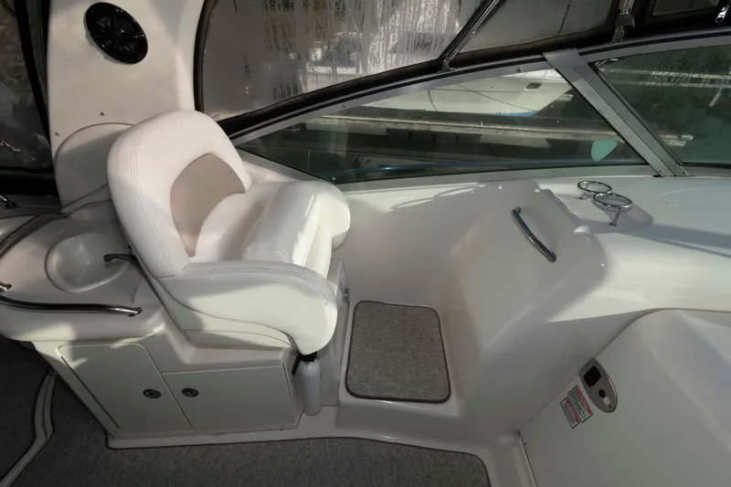Slide: The Image of Interior of 2004 Sea Ray 340 Sundancer boat with white captain's chair and helm. - 11