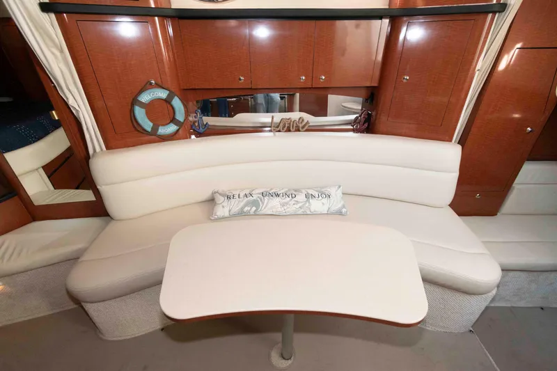 Slide: The Image of Interior of 2004 Sea Ray 340 Sundancer with cream seating and wooden cabinetry. - 13