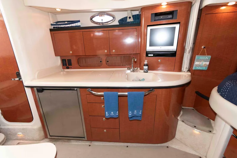 Slide: The Image of 2004 Sea Ray 340 Sundancer cabin with kitchenette, sink, and TV. - 14