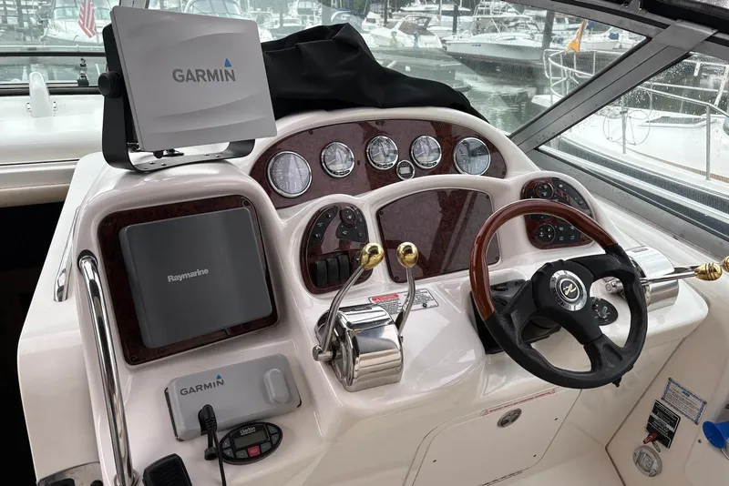 Slide: The Image of 2004 Sea Ray 340 Sundancer docked at marina, featuring sleek design and black canopy. - 3