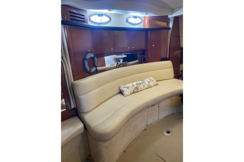 Slide: The Image of Interior of 2004 Sea Ray 340 Sundancer with white seating and nautical-themed pillows. - 6