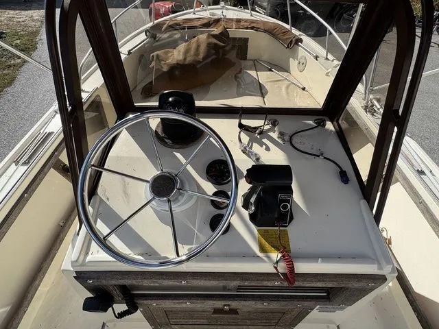 Slide: The Image of 1990 Mako 201 boat dashboard with steering wheel and controls. - 10