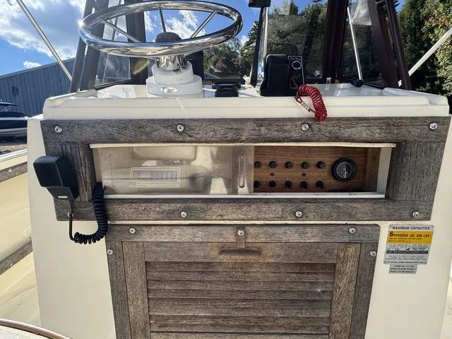 Slide: The Image of 1990 Mako 201 boat dashboard with steering wheel and control panel. - 11