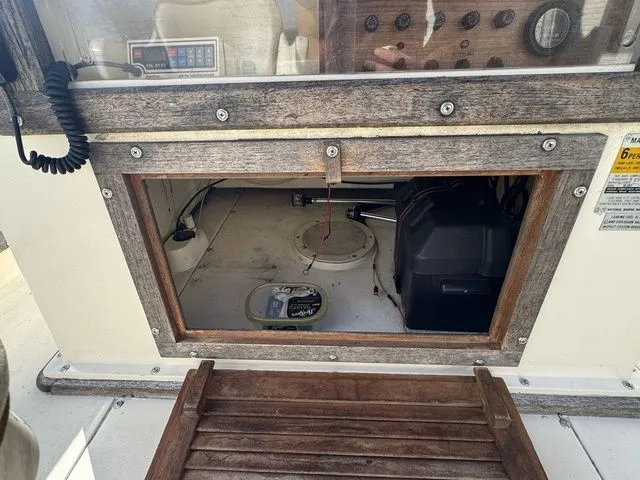 Slide: The Image of 1990 Mako 201 boat interior showing control panel and storage compartment. - 14