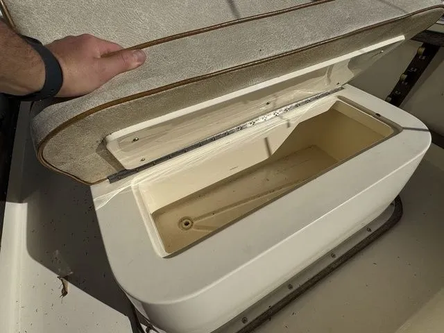 Slide: The Image of Open storage compartment on a 1990 Mako 201 boat, with cushioned lid. - 19