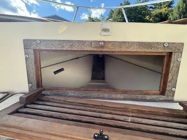 Slide: The Image of 1990 Mako 201 boat cabin entrance with wooden frame under a clear blue sky. - 21