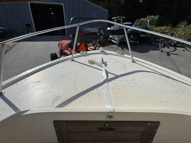 Slide: The Image of Bow view of a 1990 Mako 201 boat in a yard setting. - 22