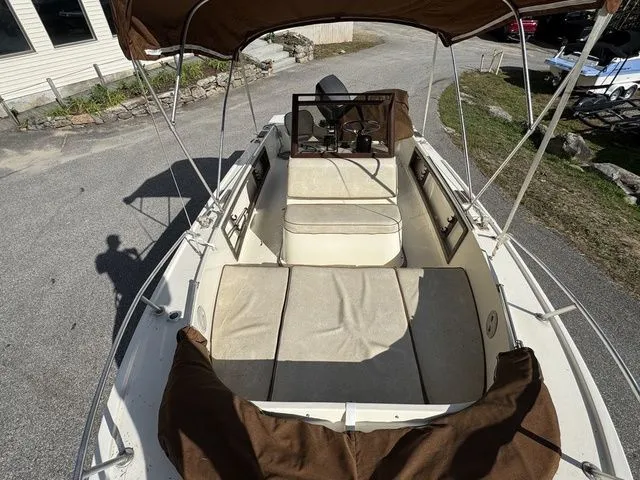 Slide: The Image of 1990 Mako 201 boat interior with brown canopy and seating. - 23