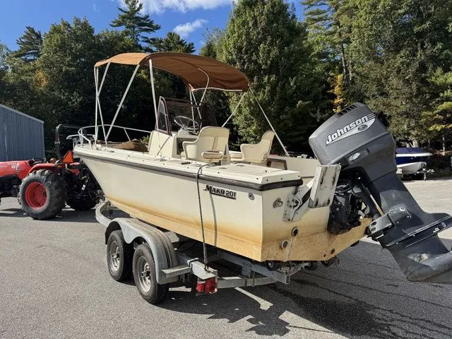 Slide: The Image of 1990 Mako 201 boat on trailer with Johnson outboard motor, parked outdoors. - 3
