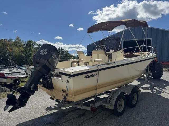 Slide: The Image of 1990 Mako 201 boat on trailer with outboard motor, parked outdoors under sunny sky. - 5